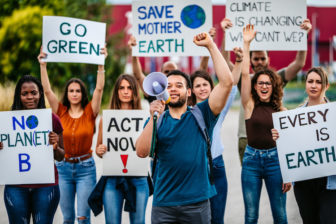 Protest march with environmental signs and speaker in front with megaphone