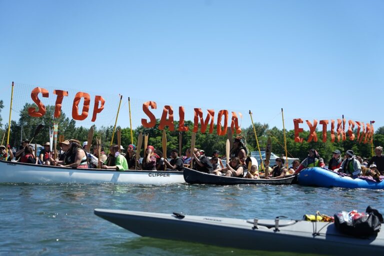 Kayakers on water with banner