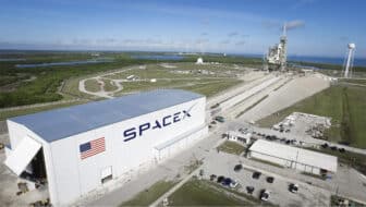 SpaceX facility viewed from above via drone shot on a sunny day.